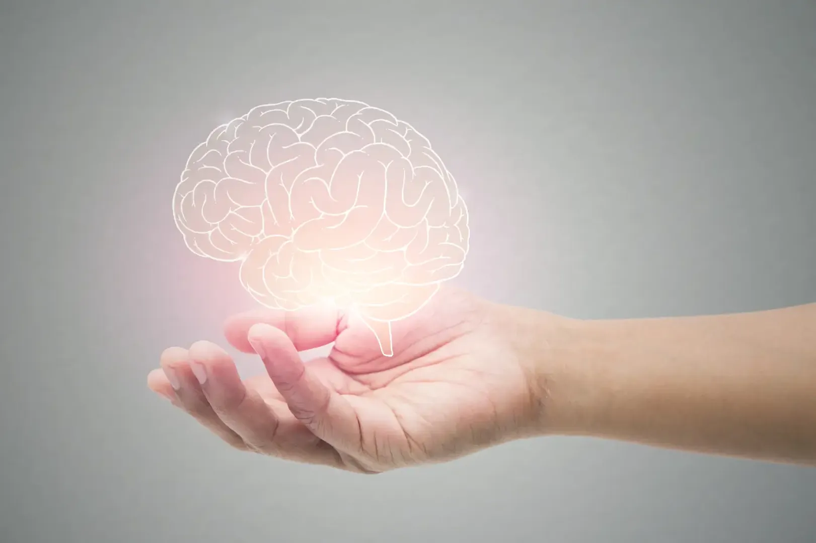 Person's had holding a glowing illustration of a brain