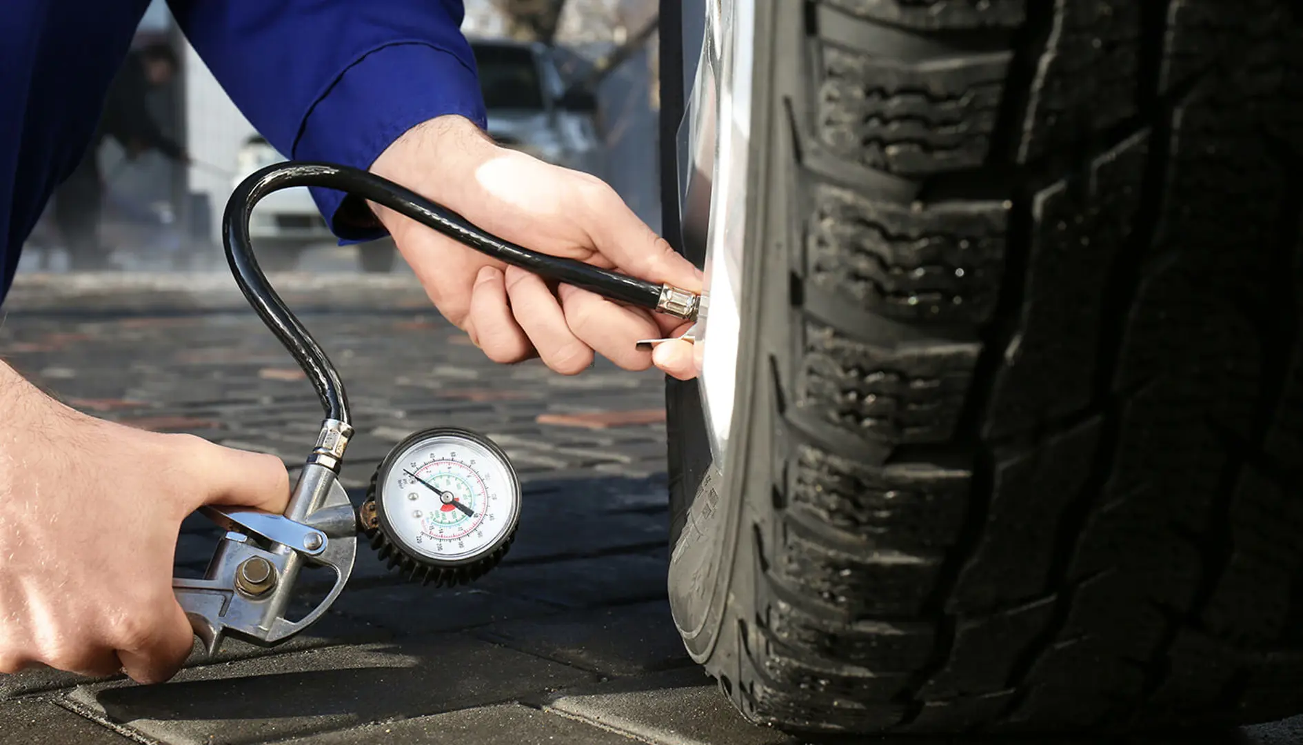 Mechanic filling tyre with air.